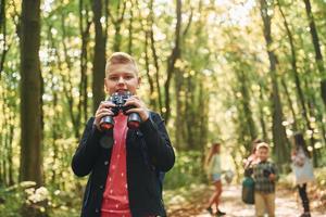 Founding the way. Kids in green forest at summer daytime together photo