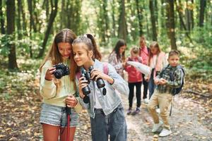 Conception of tourism. Kids in green forest at summer daytime together photo