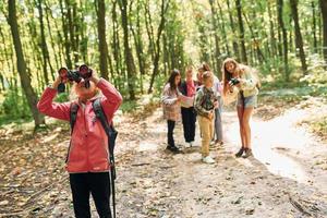 Front view of kids that is in green forest at summer daytime together photo