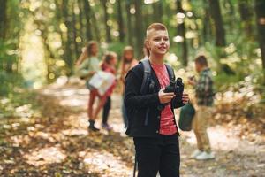 Having a walk. Kids in green forest at summer daytime together photo