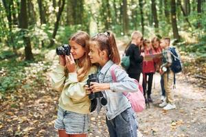 Looking for a path. Kids in green forest at summer daytime together photo