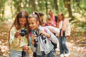 Front view of kids that is in green forest at summer daytime together photo