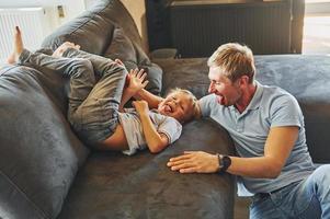 Playing and having fun. Father and son is indoors at home together photo