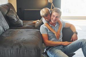 Having fun. Father and son is indoors at home together photo