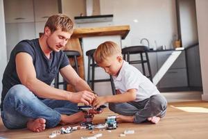 Fun weekend time spending. Father and son is indoors at home together photo