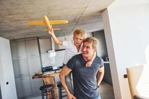 Yellow toy plane. Father and son is indoors at home together photo