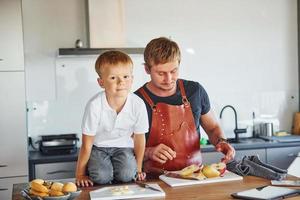 Healthy food. Father and son is indoors at home together photo