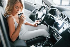 Comfortable car. Woman in formal clothes is indoors in the autosalon photo