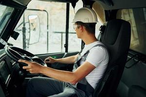 Driving transport. Worker in professional uniform is on the borrow pit at daytime photo