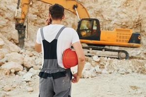 Operator is working on the borrow pit. Man in professional uniform photo