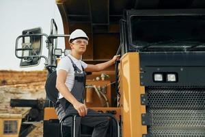 Quality vehicle. Worker in professional uniform is on the borrow pit at daytime photo