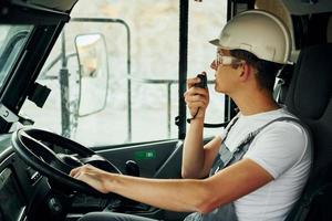 Driving transport. Worker in professional uniform is on the borrow pit at daytime photo