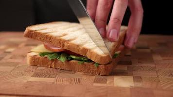 Frau schneidet ein Sandwich mit Messer video