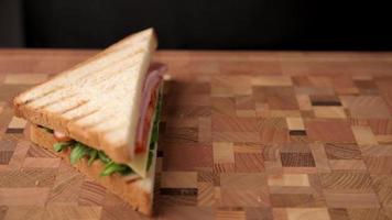 Woman bites off sandwich and puts it on the table video