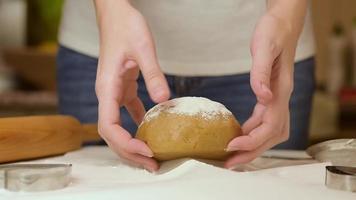 les mains d'une femme pétrissent la pâte sur la table dans la cuisine video