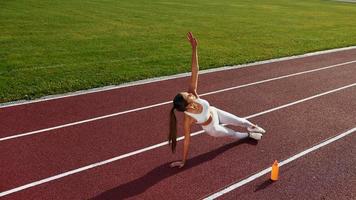 Woman is on the running track exercising outdoors photo