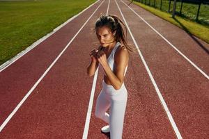 Practicing fight techniques. Young woman in sportive clothes is exercising outdoors photo