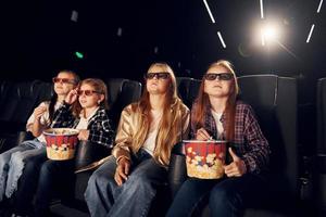 expresiones faciales. grupo de niños sentados en el cine y viendo películas juntos foto