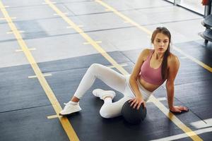 In white pants. Beautiful young woman with slim body type is in the gym photo