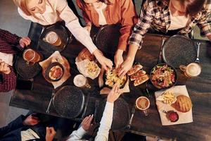 Caucasian ethnicity. Group of young friends sitting together in bar with beer photo