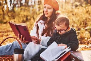 Mother with her little son is in the autumn park together photo