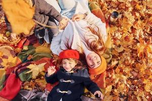 la chica lleva una boina roja. madre con su pequeña hija está paseando por el parque de otoño foto