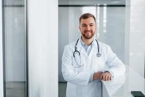 Front view. Professional medic in white coat is in the clinic photo