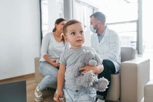 With little boy. Two doctors in white coats is in the clinic working together photo