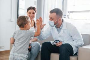 Helping kid. Two doctors in white coats is in the clinic working together photo