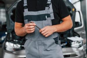 Close up view. Man in uniform is working in the autosalon at daytime photo