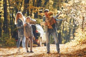 Front view. Happy family is in the park at autumn time together photo