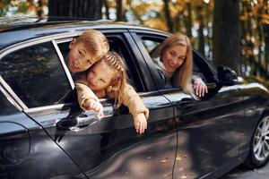 en el coche la familia feliz está en el parque en otoño juntos foto