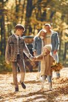 Front view. Happy family is in the park at autumn time together photo