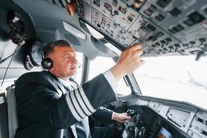 Side view. A professional pilot is in the cockpit. Conception of work photo