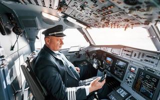 vista lateral. un piloto profesional está en la cabina. concepción del trabajo foto