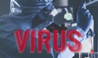 palabra de virus rojo. científico con uniforme protector que trabaja con virus en interiores en laboratorio con tubos de ensayo y microscopio foto