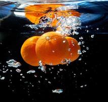 three oranges in water photo