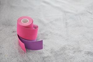 Close up view of physio tape. Two objects that colored pink and violet lying down on table photo