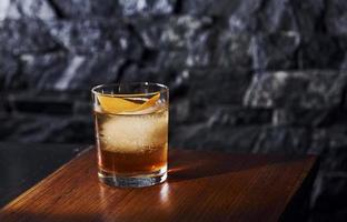 Ice cubes inside. Close up view of fresh summer cocktail on the wooden table photo