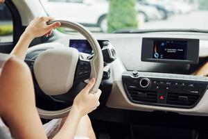 Close up view. Female driver inside of modern automobile. Testing brand new car photo