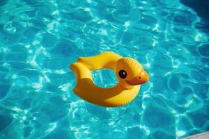 Top view of yellow duck toy for swimming in the pool at daytime photo