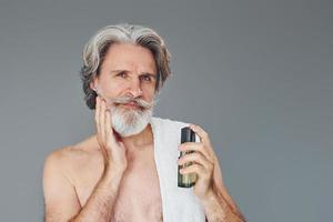 Fresh and clean face. Stylish modern senior man with gray hair and beard is indoors photo