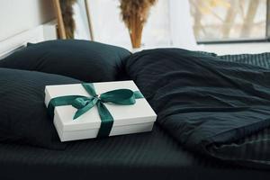 Gift box on bed. Interior and design of beautiful modern bedroom at daytime photo