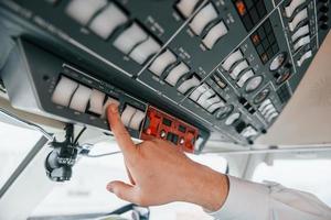 Close up view. Pilot on the work in the passenger airplane. Preparing for takeoff photo