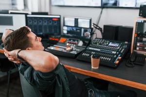 Young man is indoors in the radio studio is busy by broadcast photo