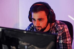 Portrait of young bearded pro gamer playing in online video game photo