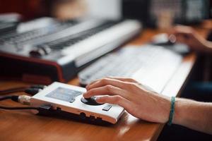 Close up vew of hand on interface. Sound engineer working and mixing music indoors in the studio photo