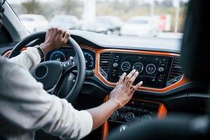 Vista de cerca de las manos de una mujer afroamericana dentro de un auto nuevo y moderno foto