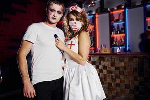 Couple is on the thematic halloween party in scary makeup and costumes photo