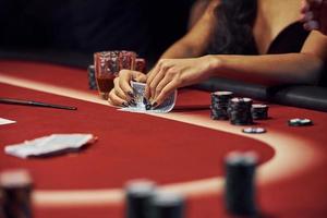 Close up view of woman's hands. Girl plays poker game by table in casino photo